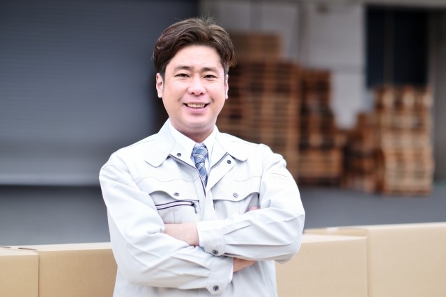 エコキュートとガス給湯器の工事について説明する男性スタッフ